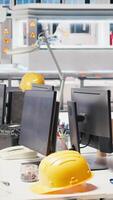 Vertical CAD program on PC monitor in photovoltaics factory used for production line design. Simulation software on computer screen in empty solar panels plant next to yellow hardhat video