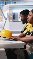 Vertical Woman with disability works in photovoltaics factory on designing solar cells, debugging and fixing malfunctioning systems. Plant worker wheelchair user ensuring operational reliability. Camera A. video