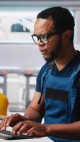 Vertical Black engineer implements automation logic in solar factory software, working on manufacturing solar panel designs for alternative energy. High tech production line. Camera A. video
