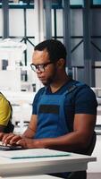 Vertical Engineer reviews energy saving configurations in solar facility at a modern workstation. Expert refines system settings to enhance renewable power generation and reduce faults. Camera A. video
