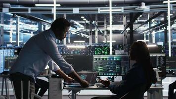 Server hub team leader and worker using node tree software to optimize system health. Data center manager supervising IT expert analyzing infrastructure issues using AI visualization, camera A video