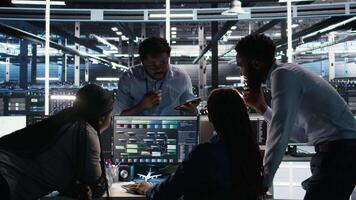 Data center coworkers doing brainstorming, using node tree software to analyze datasets. Server room teamworking colleagues using visual programming tools to improve gear performance, camera A video