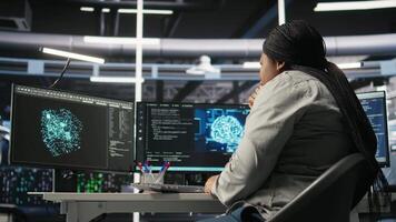 Data center technician using artificial intelligence deep learning models to configure hardware. African american woman works on AI programming language in server room, optimizing system, camera A video