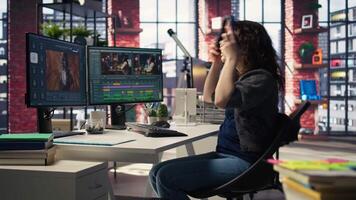 editor working on media post production from agency office, ensuring the editing timeline and color correction for a shoot. Tech driven workspace showcases workflow. Camera A. video