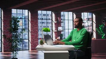 Man at home desk using laptop and checking emails displayed on screen, reading messages in inbox and sending replies. Young adult managing electronic correspondence, organizing folders. Camera B. video