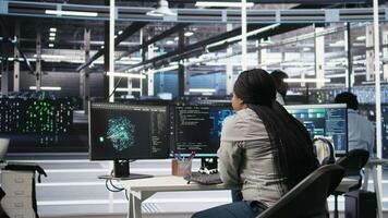 Server room specialist applies artificial intelligence technology to minimize system downtime. African American worker develops and deploys AI solutions to optimize data center equipment, camera A video