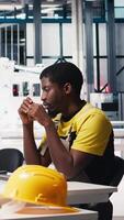 Vertical African american technician evaluates renewable energy metrics at pc station, using advanced monitoring and manufacturing tools. Engineer improves solar power system accuracy. Camera B. video