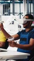 Vertical African american technician in solar panels plant using VR goggles, optimizing layouts using CAD software. Photovoltaics factory worker using virtual reality tech to do arrangements. Camera B. video