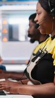 Vertical African American engineer offers service from solar panel call center, managing help line requests for support and maintenance. Customer support operator improve factory operations. Camera A. video