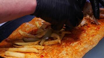 Delicious chicken wrap preparation in local eatery with toppings and fries video