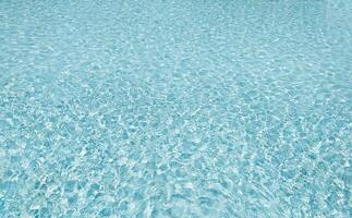 Serene turquoise water shimmers, a tranquil surface texture perfect for backgrounds, websites, or travel brochures. Its calming aesthetic evokes peace, relaxation, and summer vibes. photo