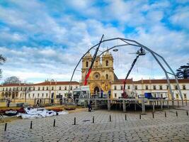 ALCOBACA, PORTUGAL - FEBRUARY 16, 2024 Construction of stage and lighting rig in front of historic monastery. Preparing for event or festival. Editorial use. photo