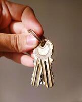 Hand holding keys. Concept of access, security, unlocking possibilities, home ownership, or property management. Use for real estate or safety related projects. photo