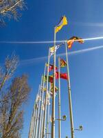LISBON, PORTUGAL - JANUARY 17, 2025 Row of flags from different countries blowing in the wind against a bright blue sky. Symbolism of unity, collaboration, diversity. photo