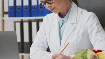 A diligent dietitian reviews patient files in a contemporary clinic. She is focused on developing nutrition strategies to support health and well-being in her European practice. video