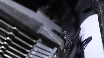 Keys hitting the paper while typing in an old qwerty typewriter video