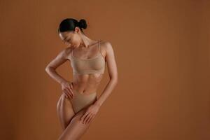 Professional, photoshoot. Woman,, with slim body shape is posing against background photo