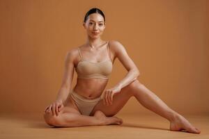 Professional, photoshoot. Woman, with slim body shape is posing against background photo