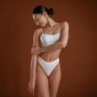 Showing,brand ,,new underwear. Woman with slim body shape is posing against background photo