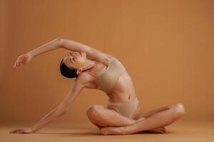 Doing fitness,, exercises. Woman with slim body shape is posing against background photo
