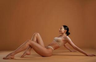 Laying down ,,on ,the ground. Woman with slim body shape is posing against background photo