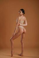 Back and ,side view. Woman with slim body shape is posing against background photo