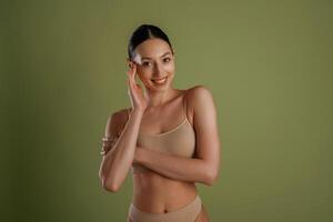 Smiling, cheerful facial,, expression. Woman with slim body shape is posing against background photo