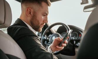 Man in black suit ,is, sitting in the car, driving photo