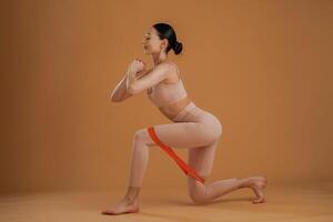 Doing squats. Beautiful, fitness woman is in the studio photo