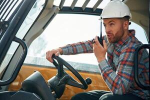 Using ,radio, talking. Man, is,, with tractor. Agricultural worker photo