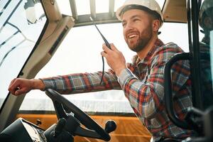 Using, radio, talking.. Man is with tractor. Agricultural worker photo