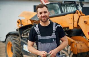 Job well done, with cloth, to clean ,the hands. Man is with tractor. Agricultural worker photo