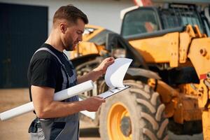 Man is with tractor. Agricultural worker. photo
