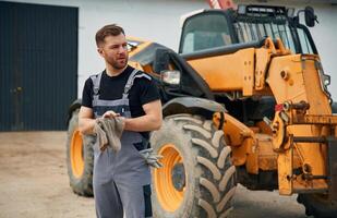 Cleaning the hands after job is done,, mechanic. Man is with tractor. Agricultural worker photo