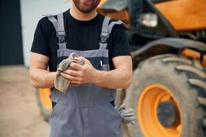 Cleaning the hands after job is done,,, mechanic. Man is with tractor. Agricultural worker photo
