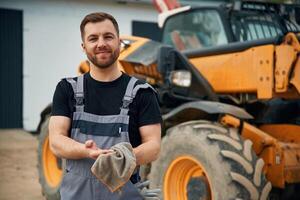 Cleaning the hands, after job is done, mechanic. Man is with tractor. Agricultural worker photo