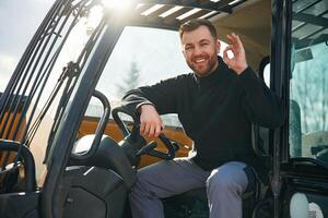 Sitting in ,the,, vehicle. Man is with tractor. Agricultural worker photo