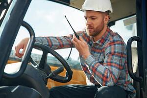 Using, radio, talking. Man is with tractor. Agricultural worker photo