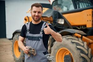 Job, well done, with cloth to clean the hands. Man is with tractor. Agricultural worker photo