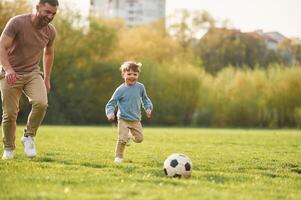 Learning, to, play,, soccer. Happy father with son are having fun on the field at summertime photo