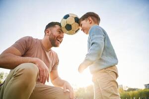 Soccer, ball, holding, it by heads, fun. Happy father with son are on the field at summertime photo