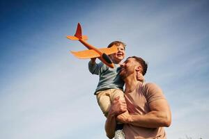 Blue sky with white cloud... Father, is holding son that playing with toy plane photo