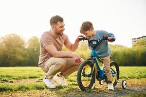 With, bicycle, having ,fun. Happy father with son are on the field at summertime photo