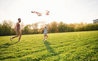 Red kite.. Happy father with son are having fun on the field at summertime photo