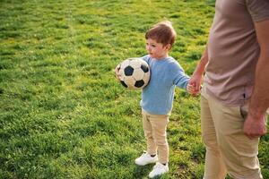 Game of ,soccer. With ball. Happy father with son are having fun on the field at summertime photo