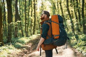 Enjoying warm weather ,and ,nature. Bearded man is in the forest at daytime photo