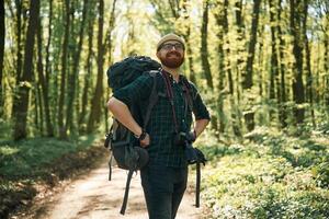 Front, view... Bearded man is in the forest at daytime photo