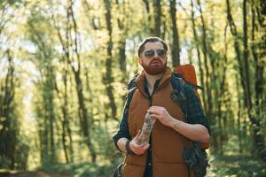 Enjoying, warm ,weather and nature. Bearded man is in the forest at daytime photo