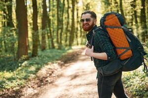 With backpack. Bearded man ,is, in, the forest at daytime photo