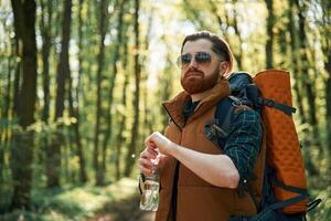 Enjoying, warm weather and nature. Bearded man is in the forest at daytime photo